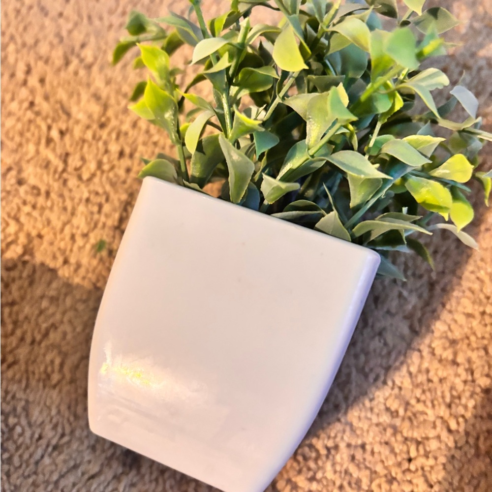 white planter with fake green plant